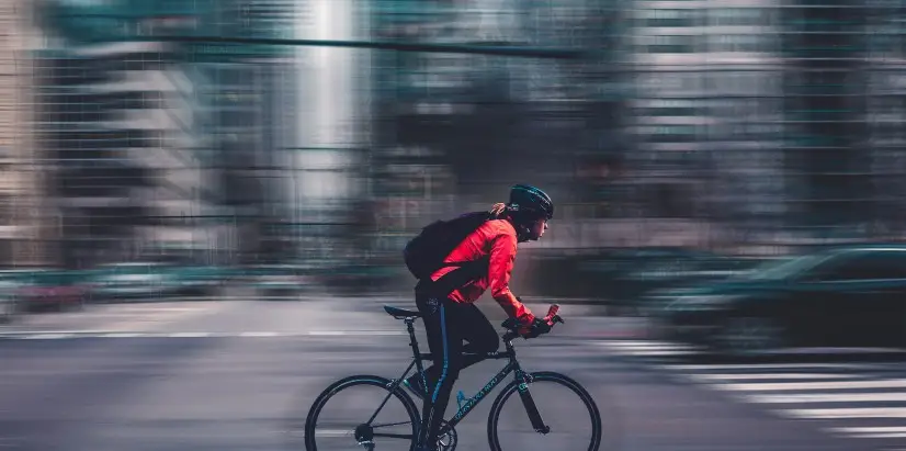 A cyclist on a busy and blurry city street.