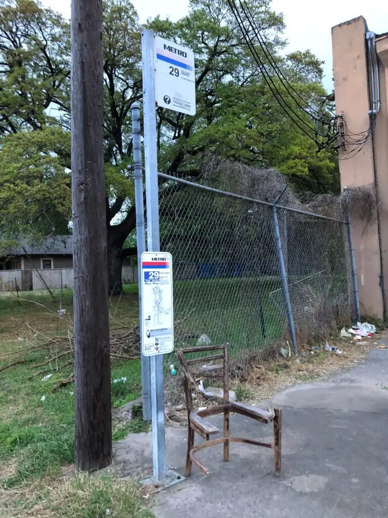 A broken chair next to a METRO bus stop pole. METRO needs all possible revenue to help improve current services such as bus stops.