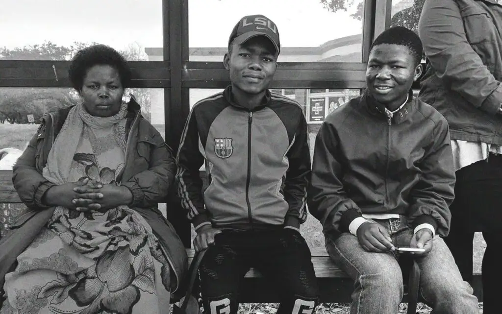 The Madilu family waits at a bus stop three weeks after arriving in southwest Houston from a refugee camp in Burundi. With the help of Catholic Charities, the family is learning how to navigate the city without a vehicle. Photograph by Peter Holley