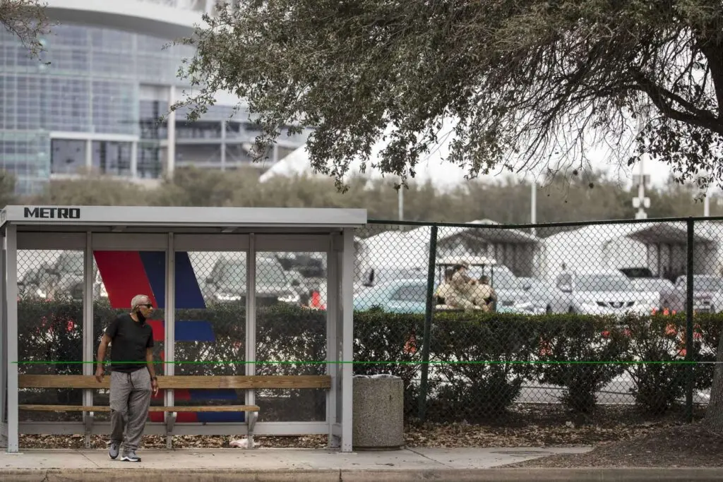 "A man waits at a bus stop along Main Street next to the a Federal Emergency Management Agency COVID-19 vaccination super site at NRG Park Wednesday, Feb. 24, 2021 in Houston. Despite being one of the most transit-friendly locations in the region with access to light rail and bus service, walk-ups are not part of the plan presently at the site that opened Wednesday in coordination with the FEMA.Brett Coomer/Staff photographer"