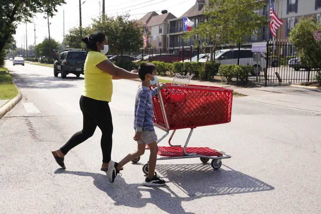 "People cross the street along Gulfton near Westward on June 17, 2021 in Houston. About 12 percent of households in Gulfton do not have a car, about double the average for Harris County. Melissa Phillip, Houston Chronicle / Staff photographer"