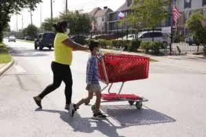 "People cross the street along Gulfton near Westward on June 17, 2021 in Houston. About 12 percent of households in Gulfton do not have a car, about double the average for Harris County. Melissa Phillip, Houston Chronicle / Staff photographer"