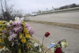 "Traffic passes by a memorial at the site of a crash that resulted in the deaths of three people. Jon Shapley, Houston Chronicle / Staff photographer"