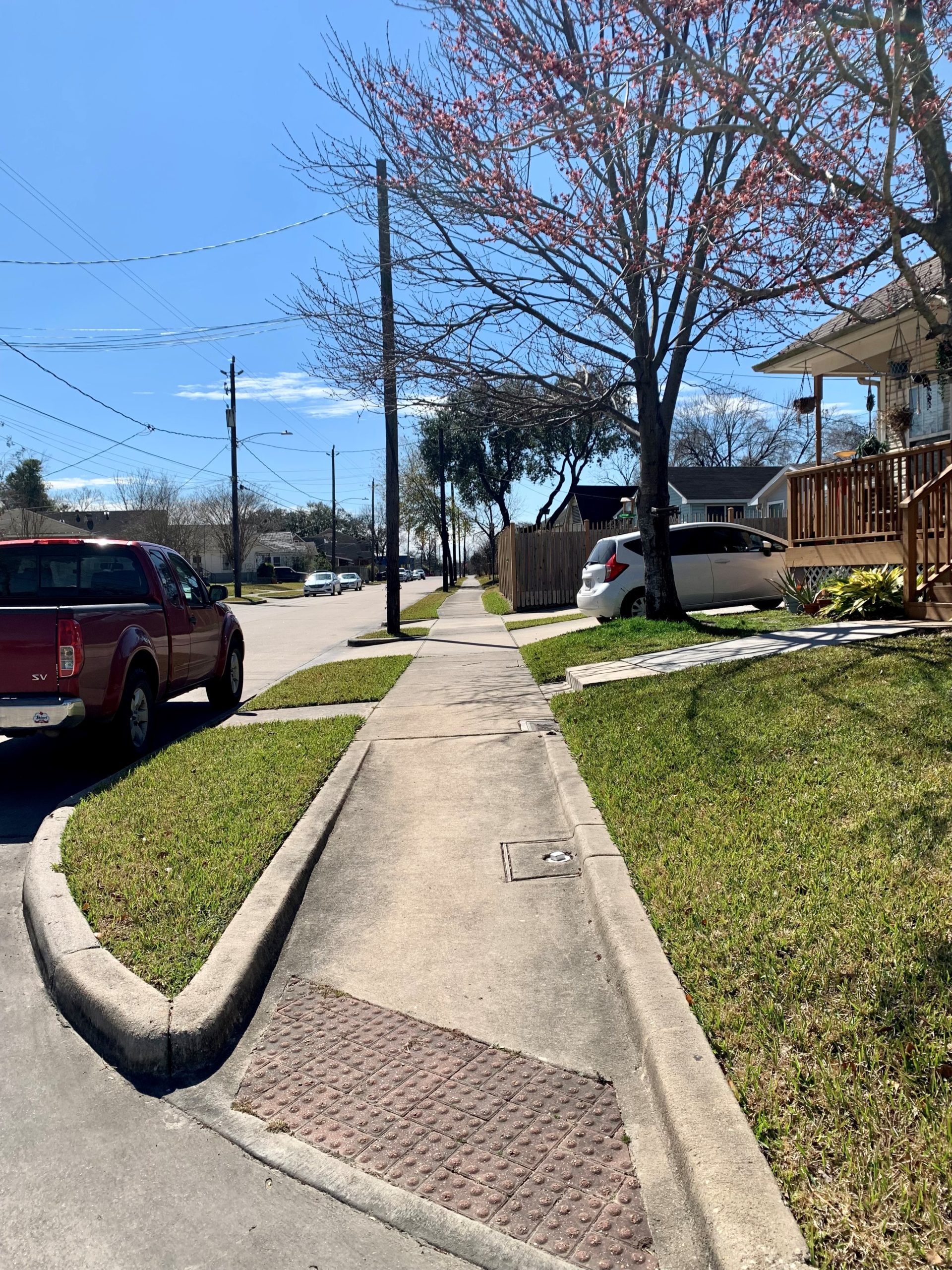 A safe, well connected, and accessible sidewalk in Second Ward. A red truck is parked on the street.