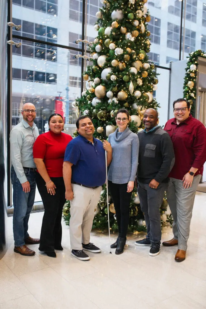 LINK Houston staff standing in front of a christmas tree in their lobby.